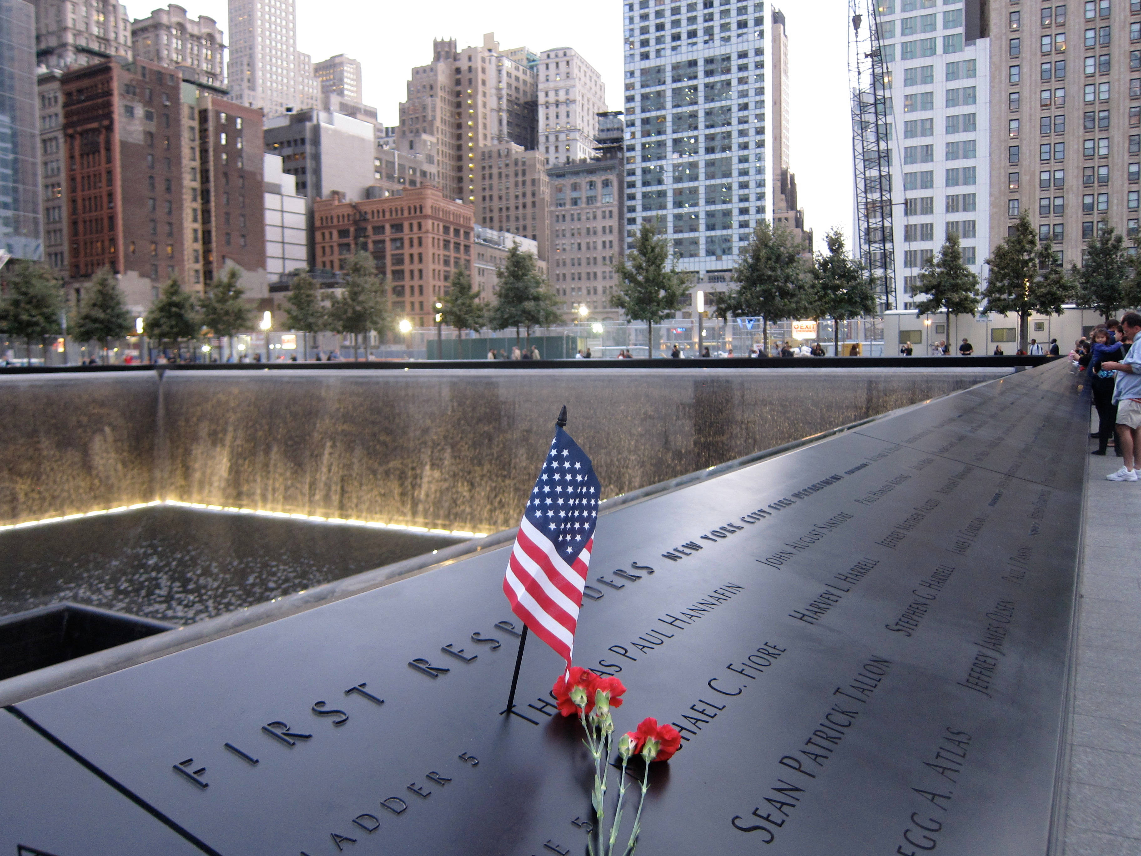 American flag and flowers left at the First Responders panel, National September 11 Memorial, honoring the FDNY