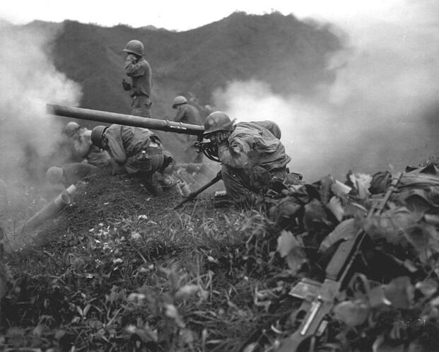 U.S. Army soldiers firing recoilless rifle on a hillside in Korea, smoke and combat action, 1952-1953